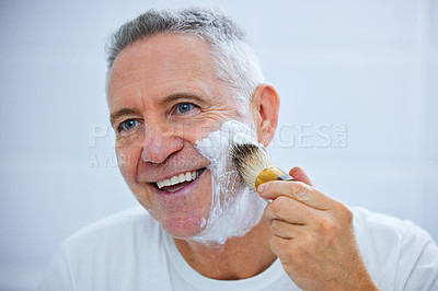 Buy stock photo Shot of a mature man applying shaving cream to his face in a bathroom at home