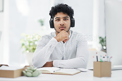 Buy stock photo Portrait of a young businessman wearing headphones while working in an office