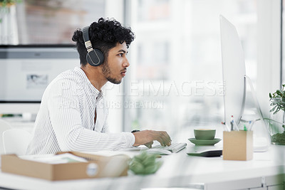 Buy stock photo Shot of a young businessman working on a computer in an office