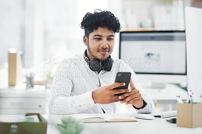 Buy stock photo Shot of a young businessman using a cellphone in an office