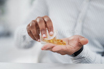 Buy stock photo Closeup shot of an unrecognisable businessman pouring pills into his hands in an office