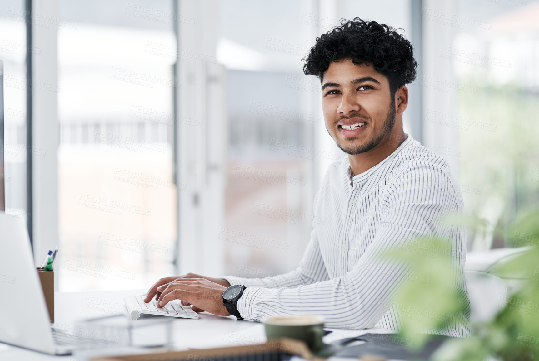 Buy stock photo Portrait of a young businessman working on a computer in an office