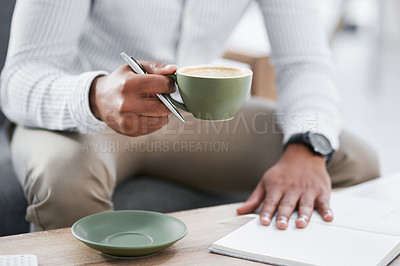 Buy stock photo Closeup shot of an unrecognisable businessman drinking coffee while writing notes in an office