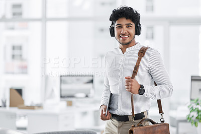 Buy stock photo Portrait of a young businessman wearing headphones and holding a digital tablet in an office