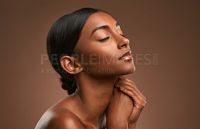 Buy stock photo Side shot of a beautiful young woman posing against a brown background