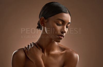 Buy stock photo Shot of a beautiful young woman posing against a brown background