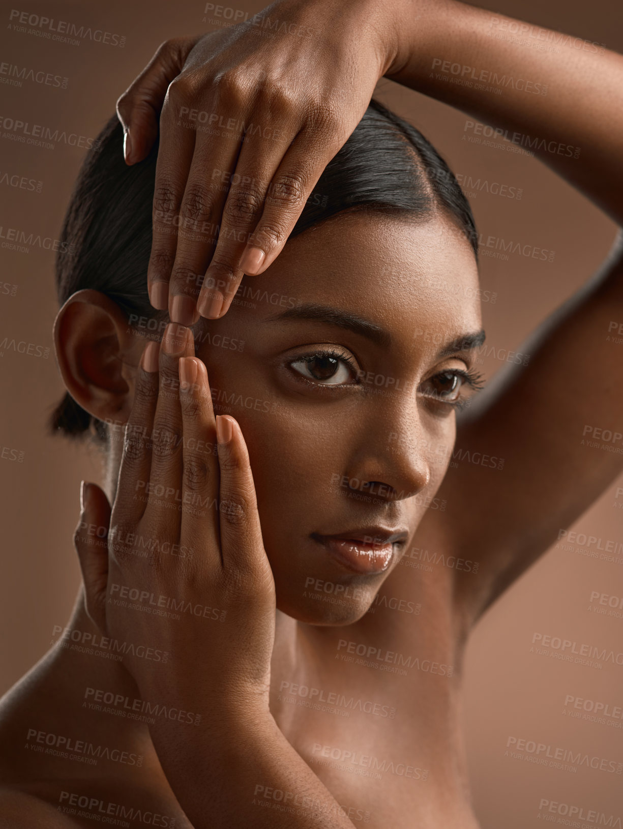 Buy stock photo Side shot of a beautiful young woman posing against a brown background