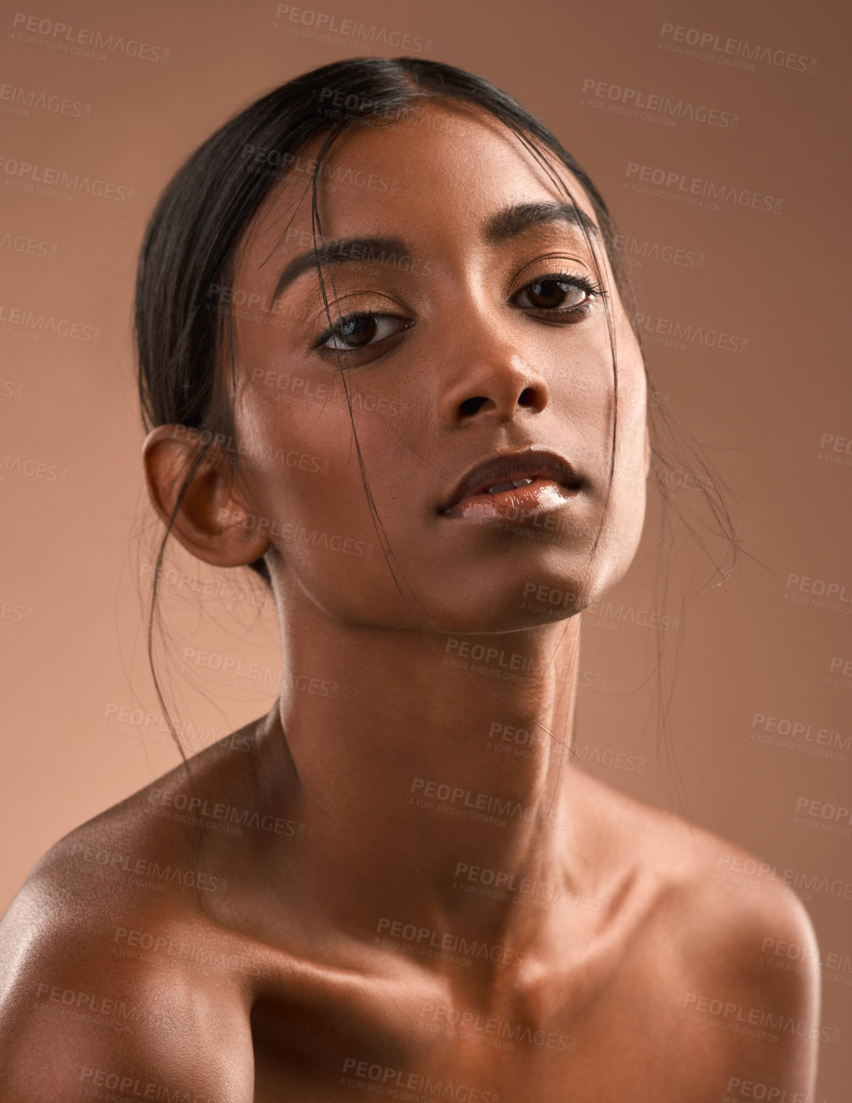 Buy stock photo Portrait of a beautiful young woman posing against a brown background