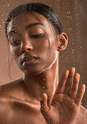 Buy stock photo Shot of a beautiful young woman having a refreshing shower against a brown background