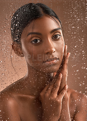 Buy stock photo Portrait of a beautiful young woman having a refreshing shower against a brown background