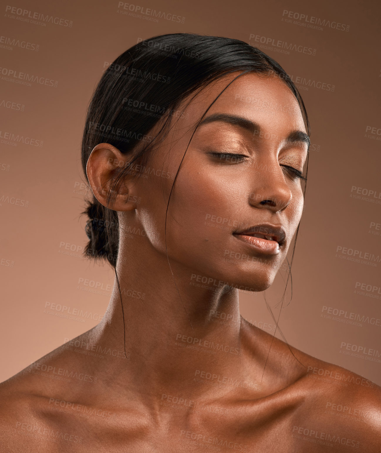 Buy stock photo Shot of a beautiful young woman posing against a brown background