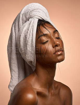Buy stock photo Shot of a beautiful young woman with her hair wrapped in a towel against a brown background