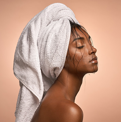 Buy stock photo Shot of a beautiful young woman with her hair wrapped in a towel against a brown background