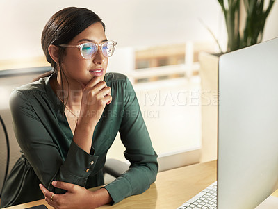 Buy stock photo Shot of a young businesswoman looking at her computer screen at work