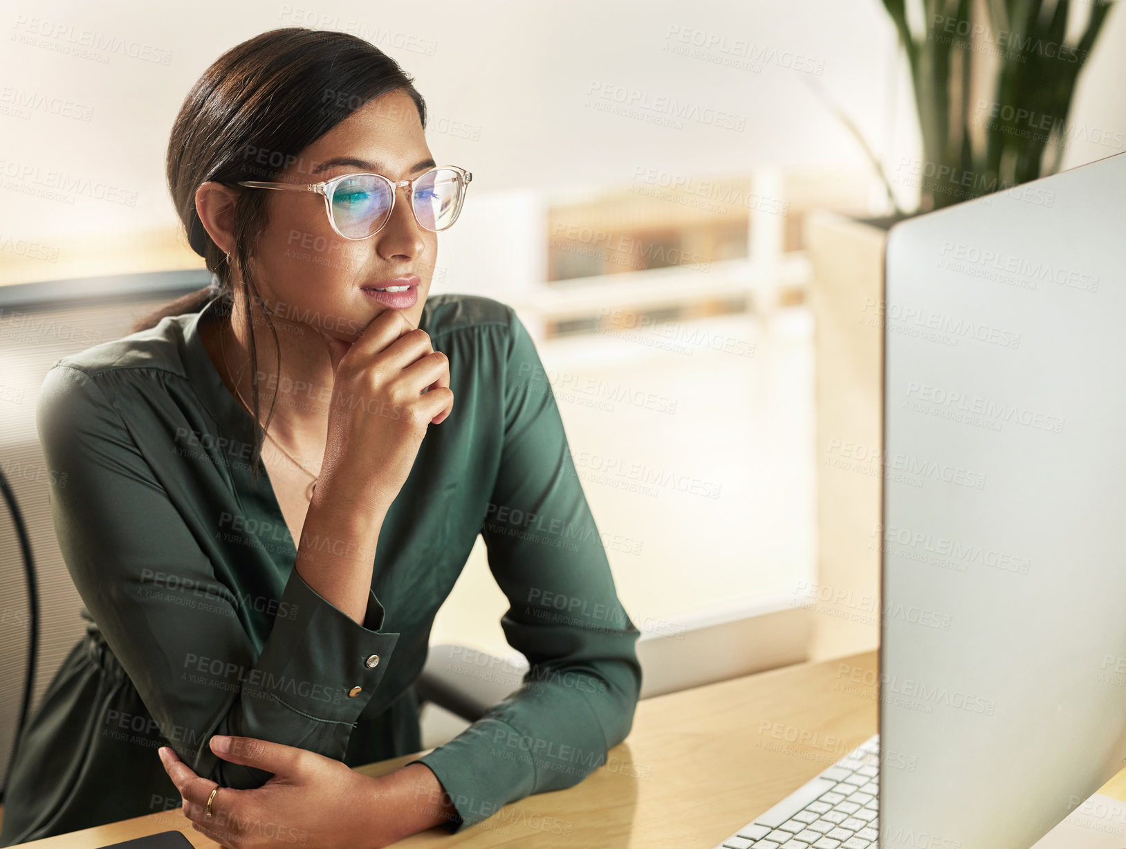 Buy stock photo Shot of a young businesswoman looking at her computer screen at work