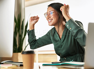 Buy stock photo Shot of a young businesswoman cheering while looking at her PC screen