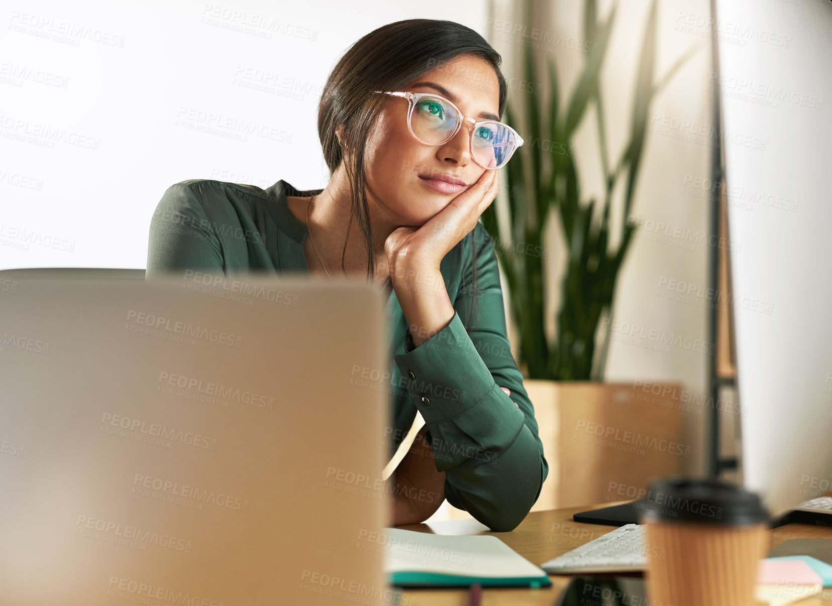 Buy stock photo Shot of a young businesswoman day dreaming at her desk