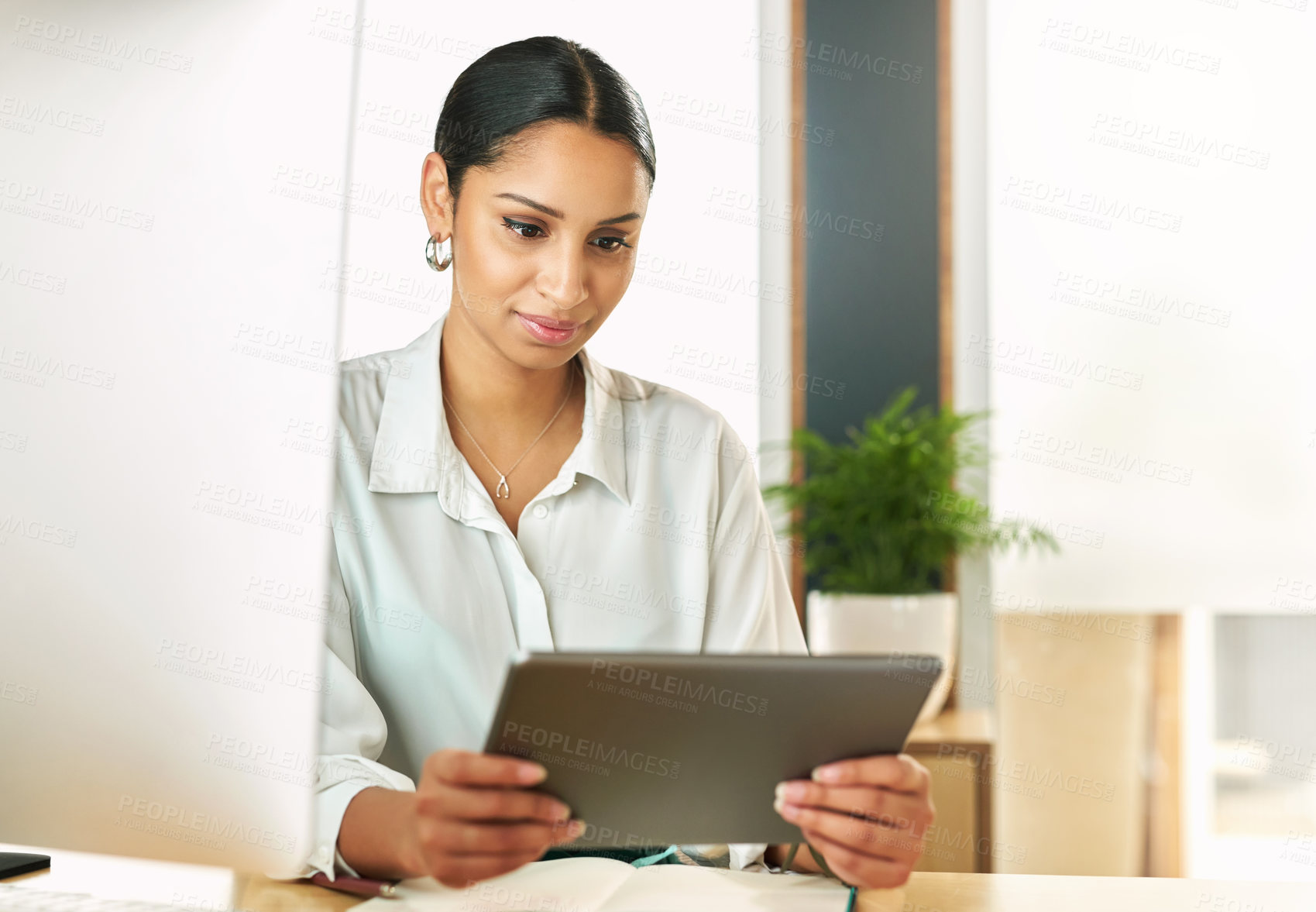 Buy stock photo Shot of a businesswoman using her digital tablet at her desk