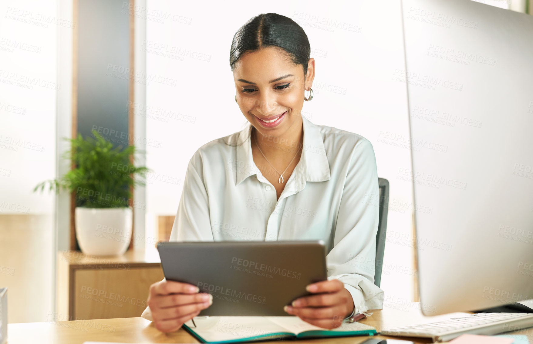 Buy stock photo Shot of a young businesswoman using her digital tablet at her desk