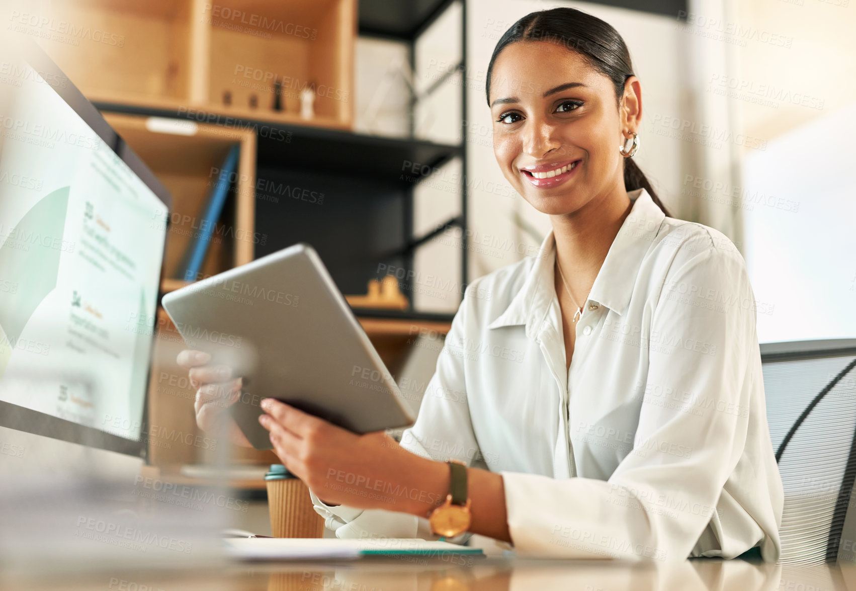 Buy stock photo Shot of a young businesswoman using her digital tablet at her desk