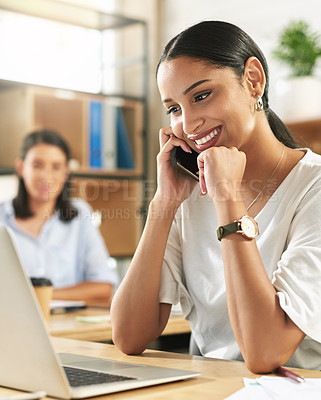 Buy stock photo Shot of a young businesswoman taking a call on her smartphone at work