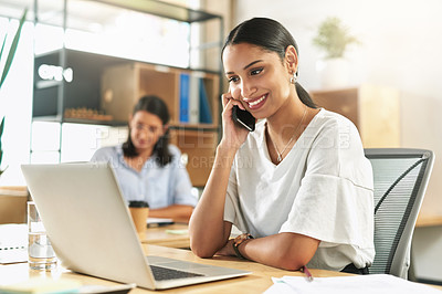 Buy stock photo Shot of a young businesswoman taking a call on her smartphone at work