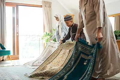 Buy stock photo Shot of a muslim family preparing their mats for prayer time at home