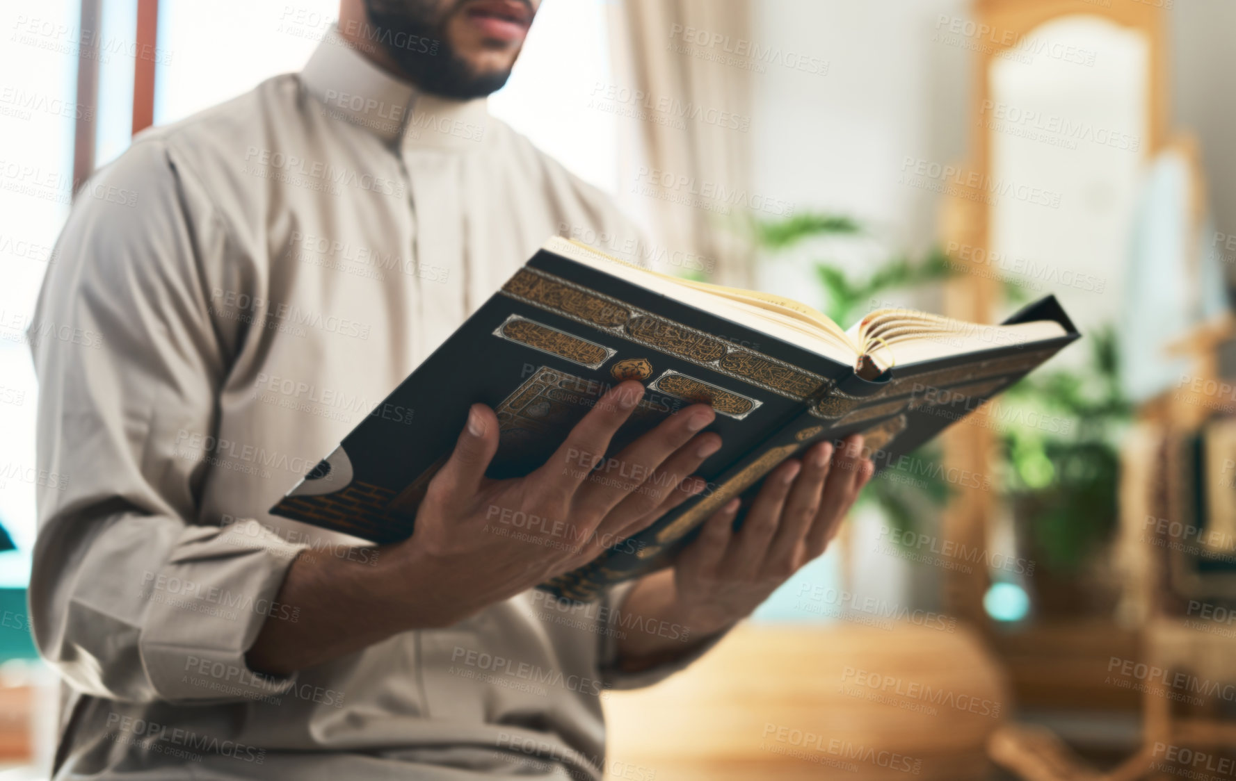 Buy stock photo Shot of a unrecognizable muslim man praying in the lounge at home