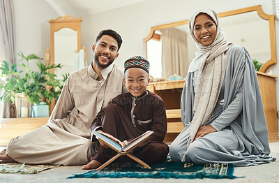 Buy stock photo Shot of a young muslim couple and their son reading in the lounge at home