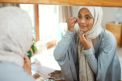 Buy stock photo Shot of a young muslim woman using the mirror at home