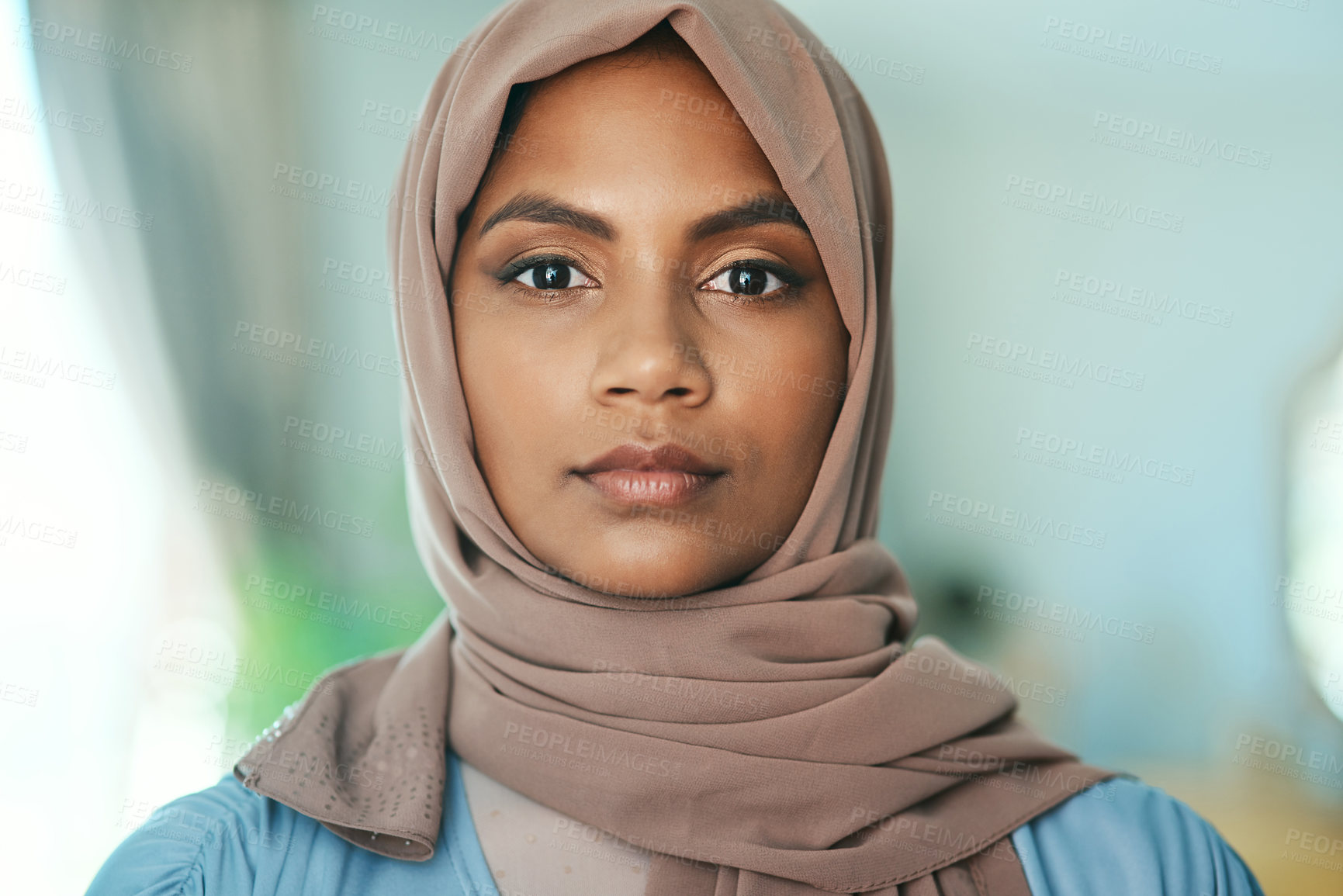 Buy stock photo Shot of a young muslim woman sitting in the loung at home