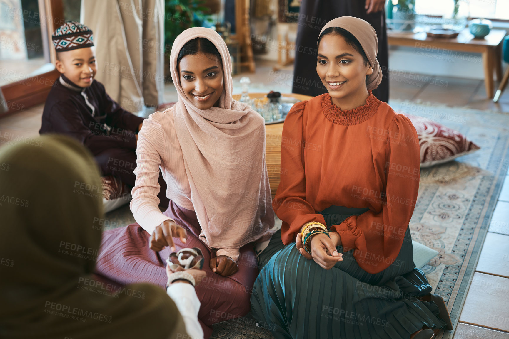 Buy stock photo Shot of a group of muslim women relaxing together about to break their fast with dates