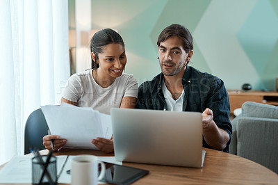 Buy stock photo Shot of a young couple doing paperwork while using a laptop at home