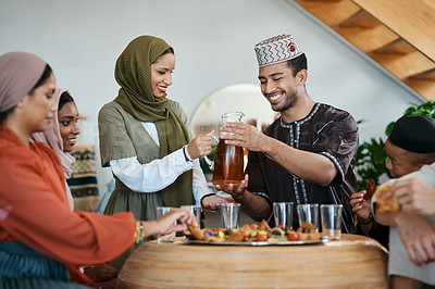 Buy stock photo Ramadan, Eid and iftar with a muslim family celebrating breaking of the fast with food and drink at home. Bonding, feeling together and enjoying a traditional islamic feast and holy celebration