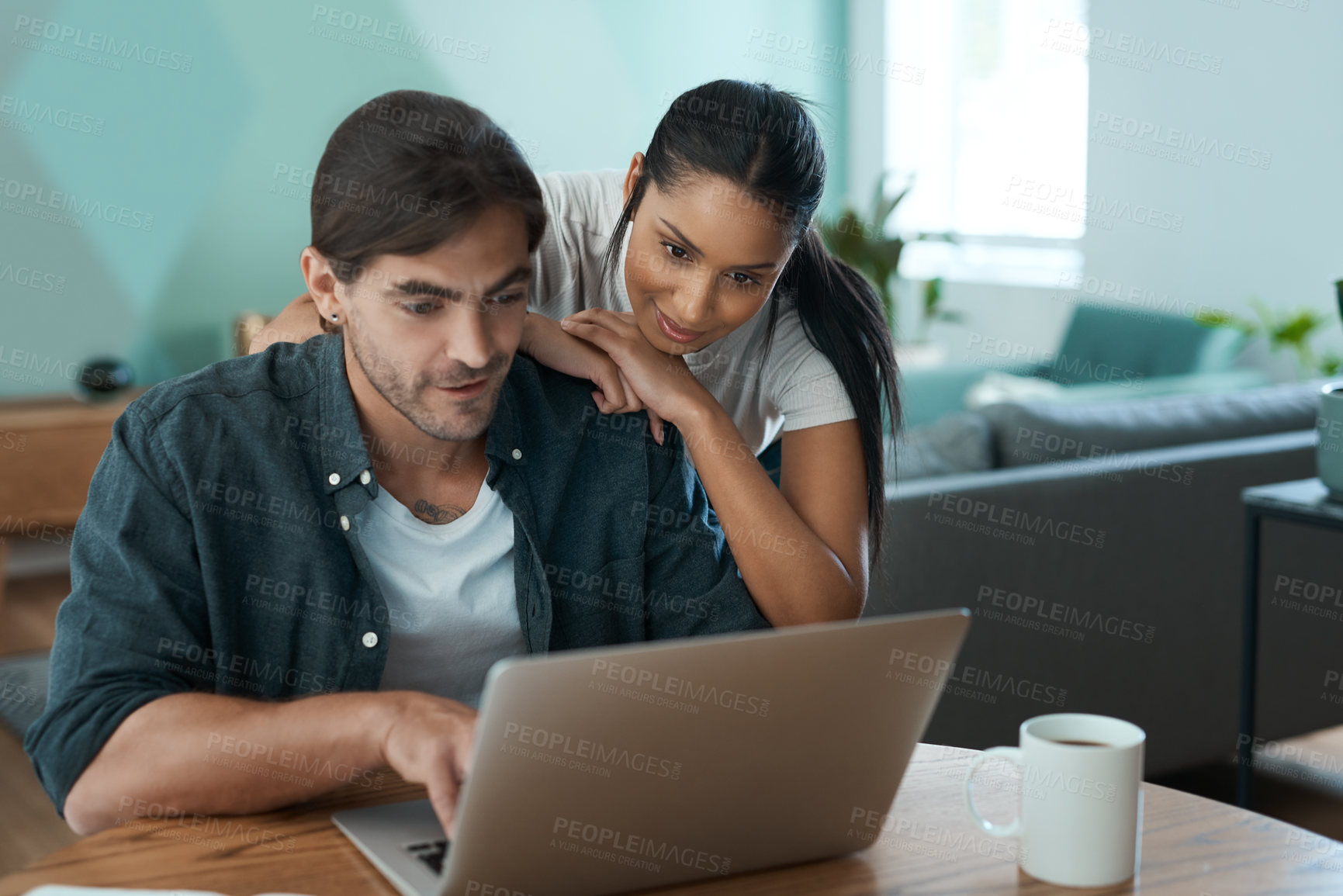 Buy stock photo Shot of a young couple using a laptop at home
