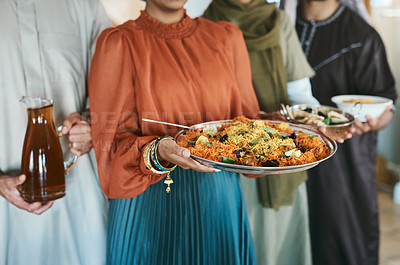 Buy stock photo Ramadan, Eid and iftar with a muslim family holding food and drink to break their fast at home together. Closeup of rice and curry in the hands of a woman with people holding other meals and juice
