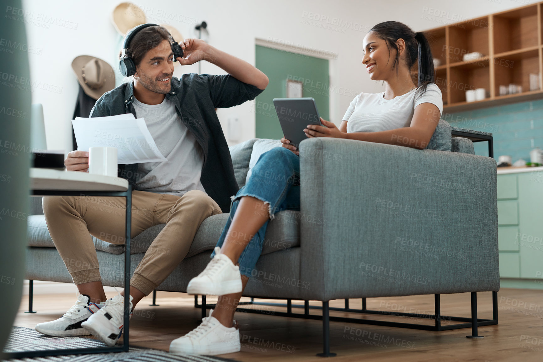 Buy stock photo Shot of a young couple doing paperwork while using a digital tablet at home