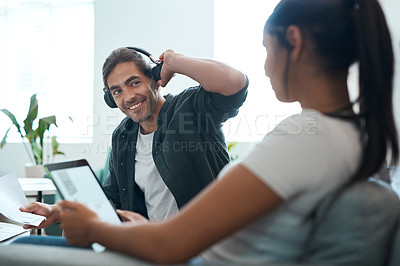 Buy stock photo Shot of a young couple sitting on a couch while doing paperwork at home