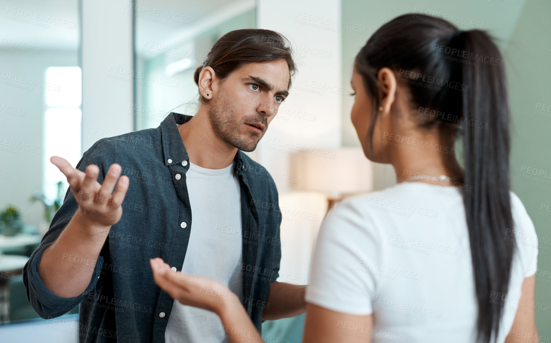 Buy stock photo Shot of a young couple having an argument at home