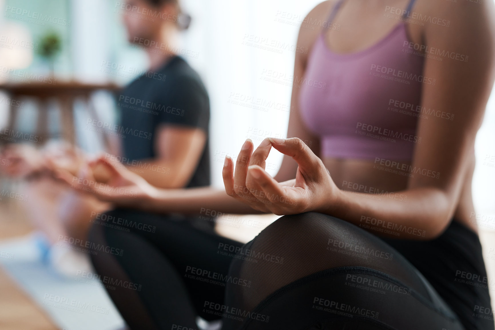 Buy stock photo Cropped shot of an unrecognizable and athletic young couple meditating during their workout at home