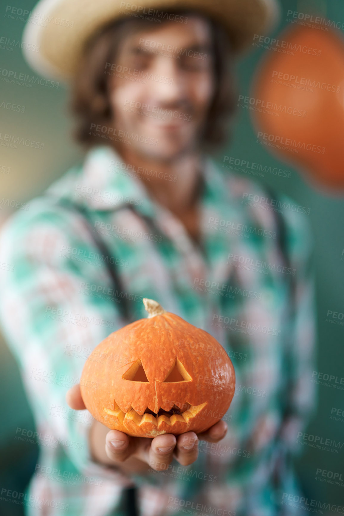 Buy stock photo Shot of an young man holding a carved pumpkin