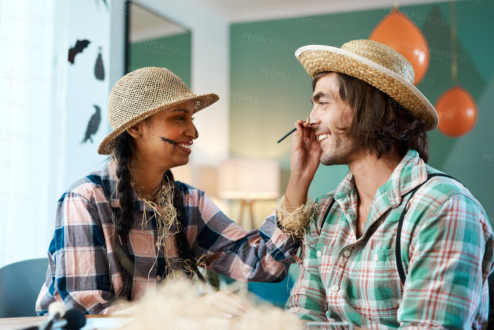 Buy stock photo Shot of a young woman applying makeup to a young man at home