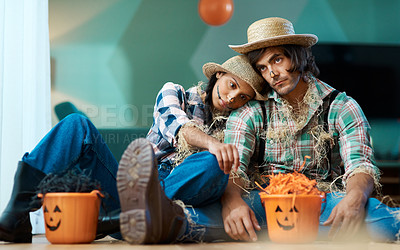 Buy stock photo Shot of a young couple dressed in halloween costumes looking sad at home