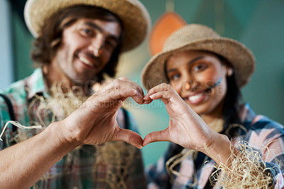 Buy stock photo Shot of a young couple making a heart gesture with their hands at home