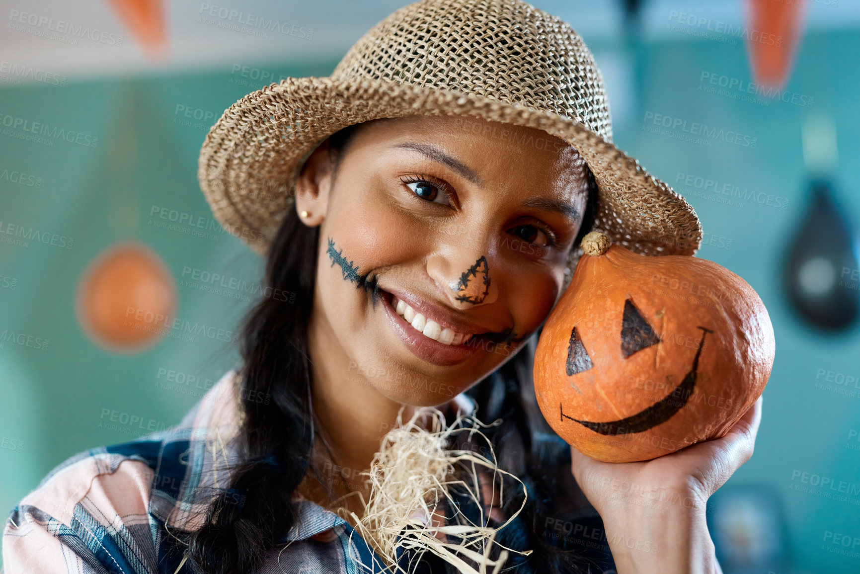 Buy stock photo Shot of a young woman holding a pumpkin at home