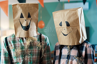 Buy stock photo Shot of a young couple with paper bags over their heads at home