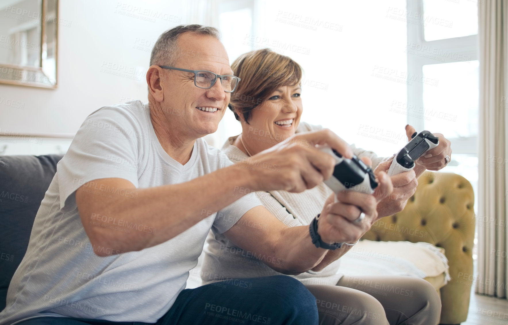 Buy stock photo Shot of a mature husband and wife playing video games together