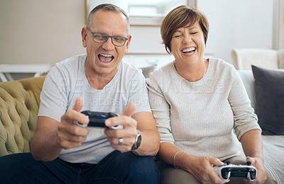 Buy stock photo Shot of a mature husband and wife playing video games together