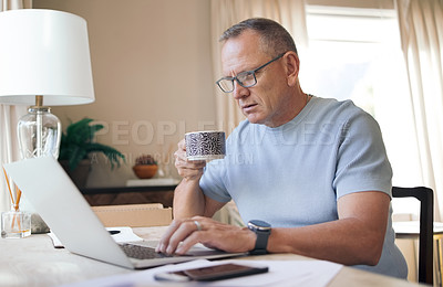Buy stock photo Shot of a mature man drinking a cup of coffee while working