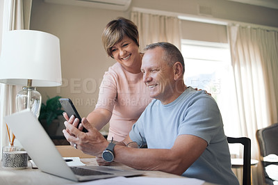 Buy stock photo Shot of a mature husband and wife together using a smartphone